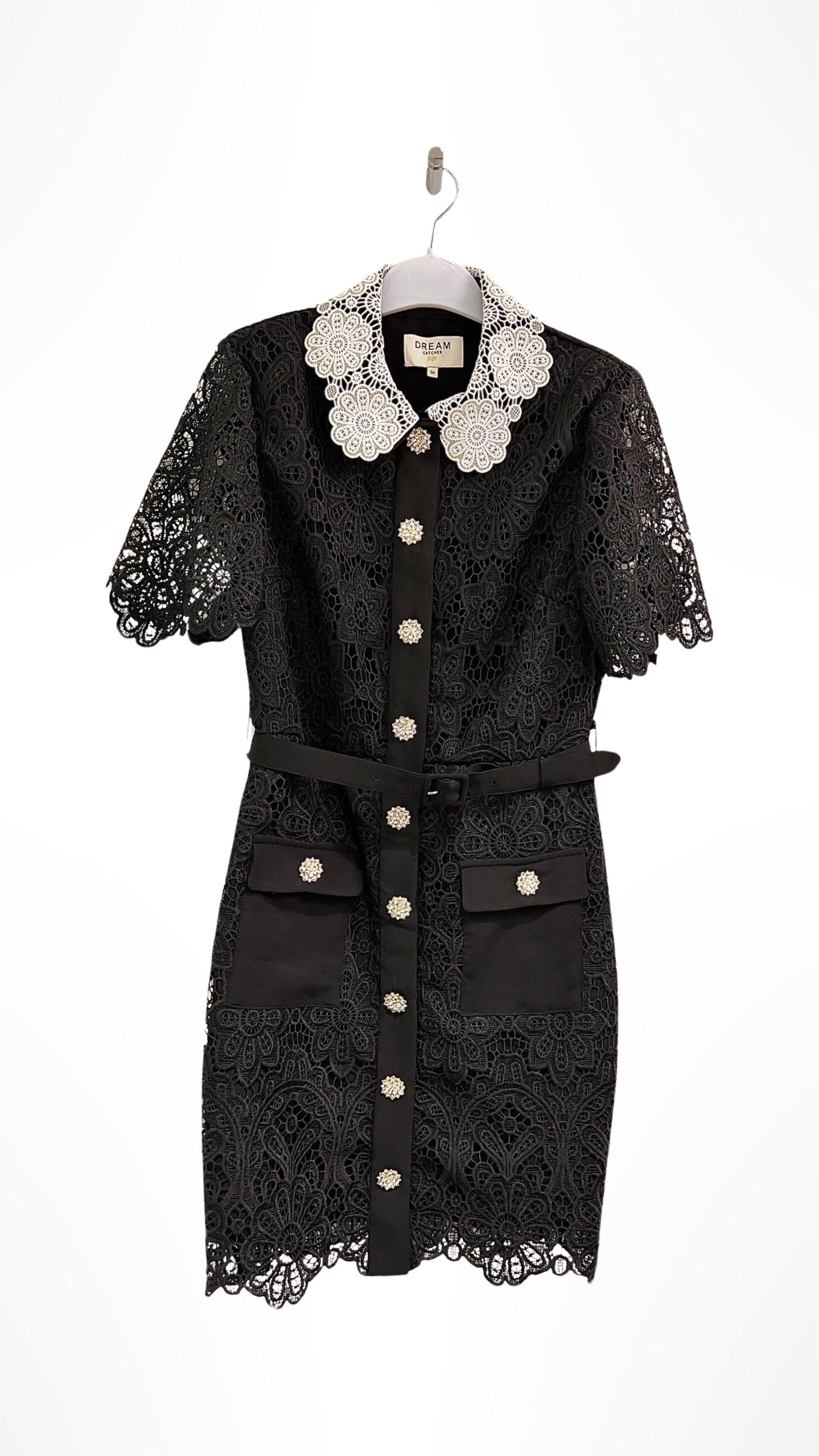 Elegant black lace dress with a distinctive white lace collar, short lace sleeves, and a row of decorative buttons down the front, displayed on a hanger  - BTK COLLECTION