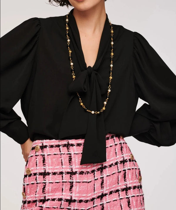 WEILL Paris black bow-neck blouse with gathered shoulders, styled with a pink tweed skirt and long necklace