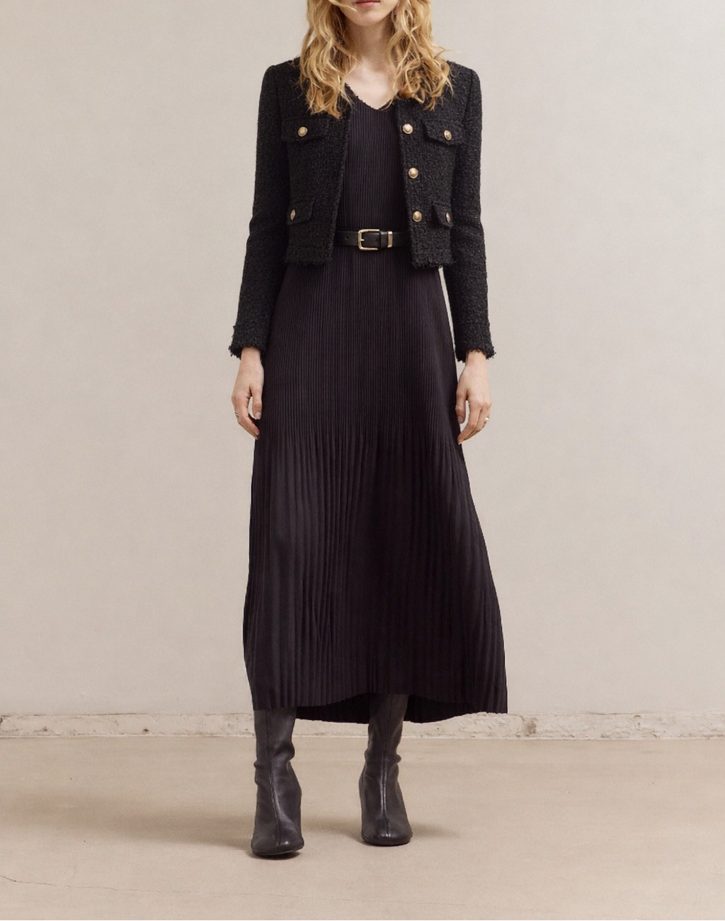 Woman wearing a black Wrinkled Pleat Sleeveless Maxi Dress outfit with a black buttoned with pocket tweed jacket  against a plain background