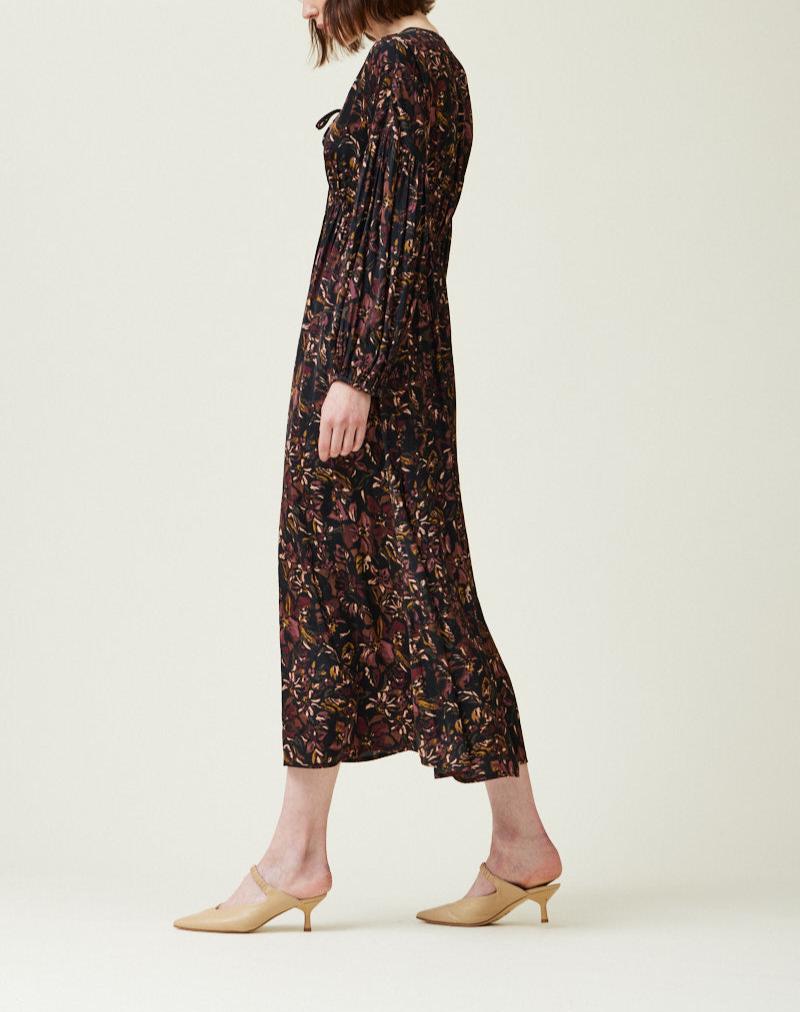 Side view of black floral satin midi dress with long sleeves