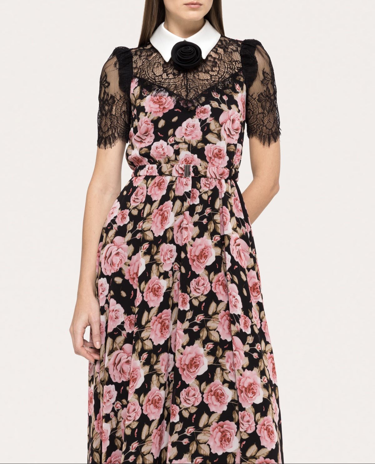 Close‑up of white collar with black rosette and scalloped lace yoke over pink rose bouquet print on black chiffon dress