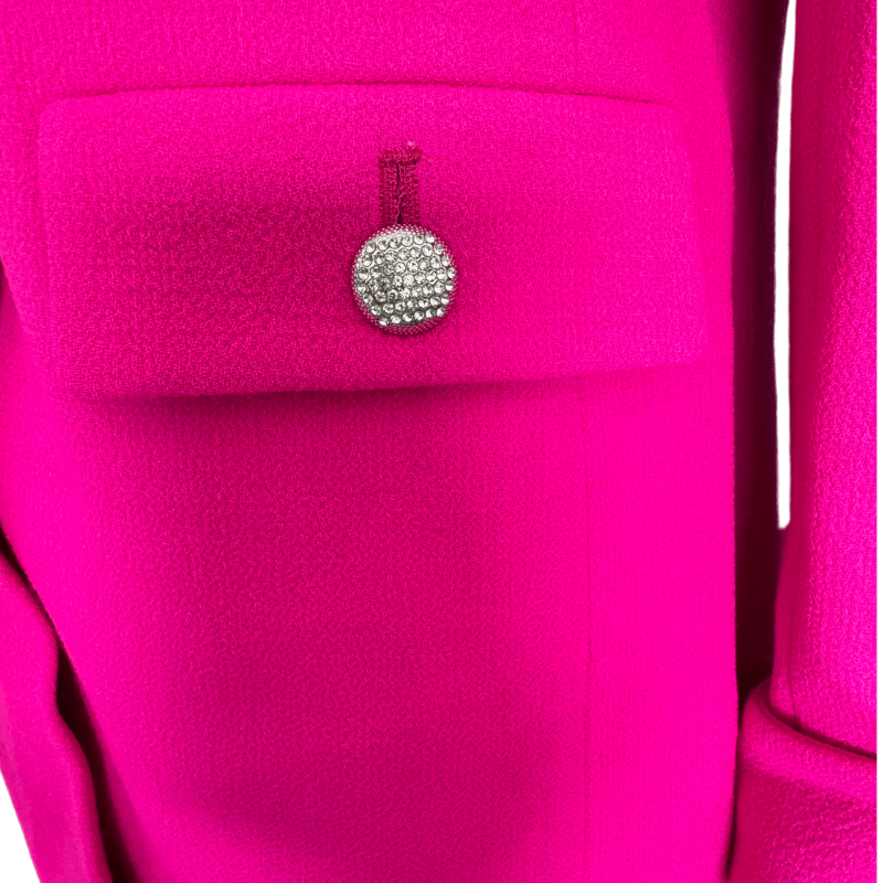 Jeweled button on a hot pink pocket flap, showing the textured wool crepe fabric of the Weill Paris jacket.