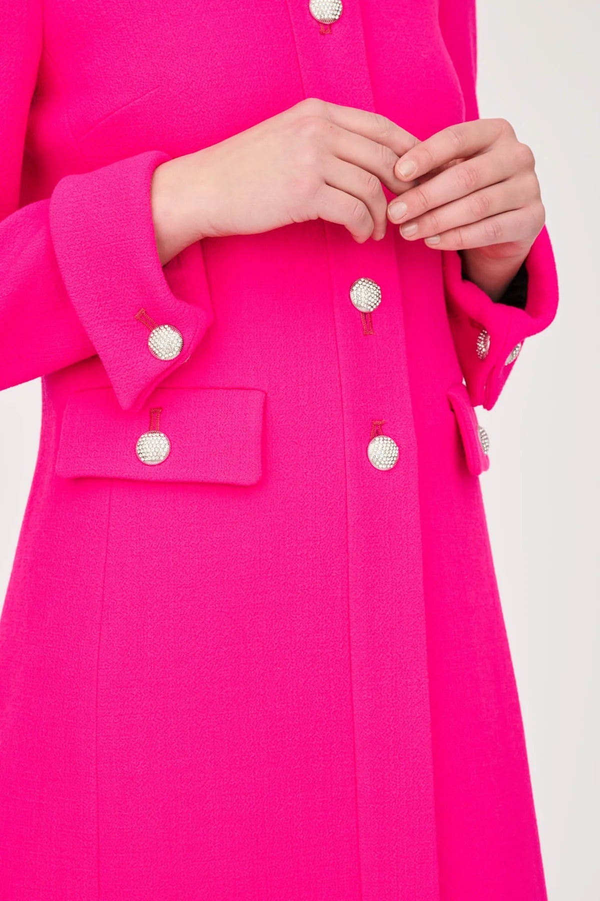 Close-up of jeweled front, pocket-flap and cuff buttons on the Weill Paris hot pink wool crepe jacket.