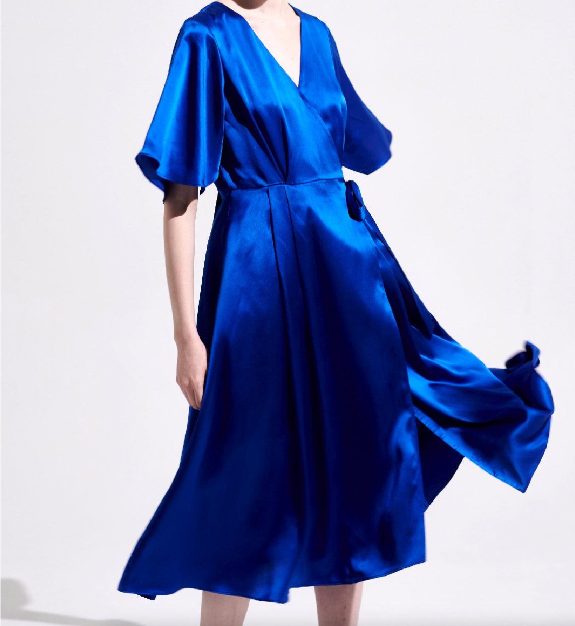 Royal blue silk wrap midi dress in motion showing fluid drape and elegant movement