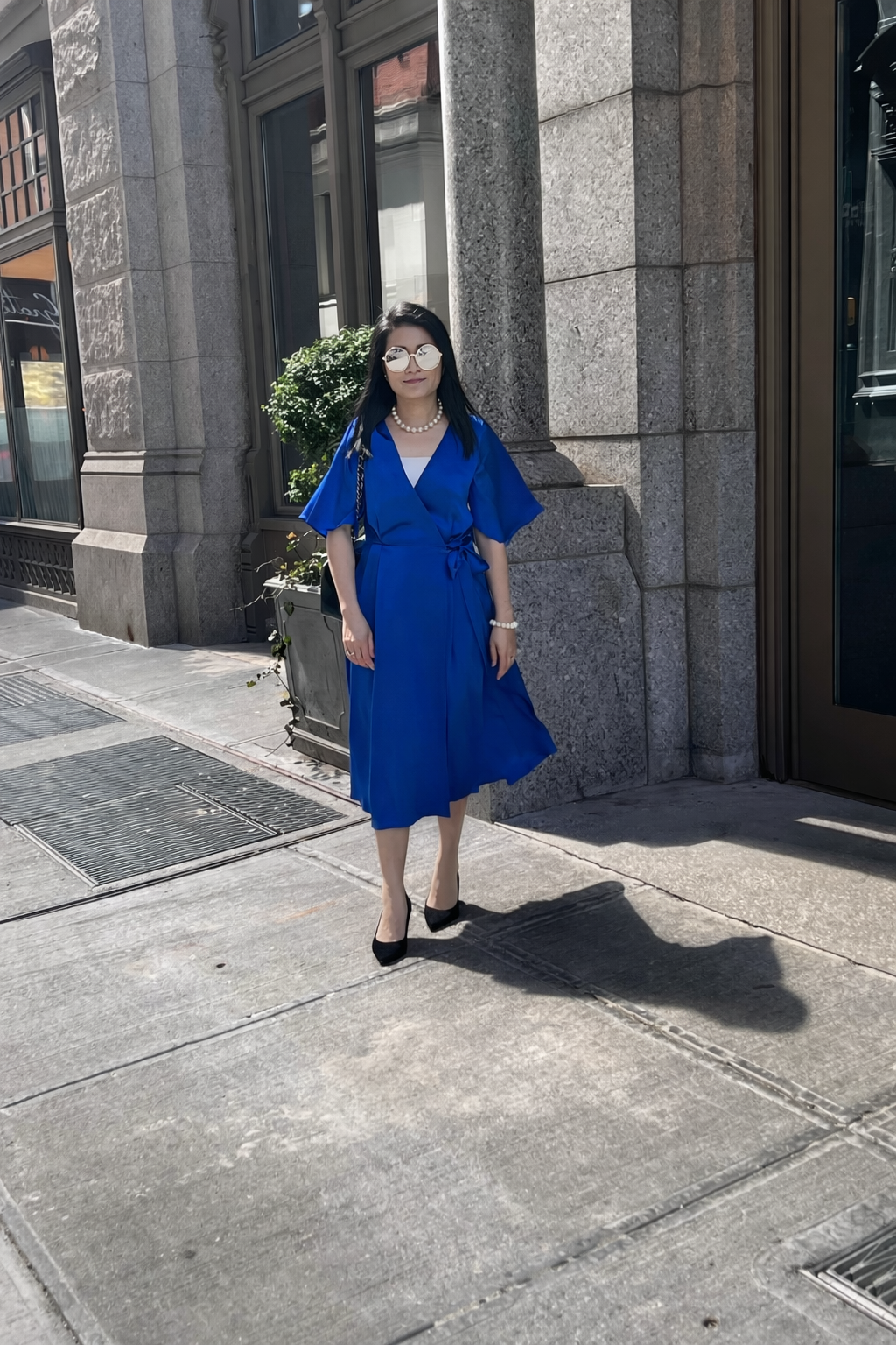 Royal blue silk wrap midi dress styled with black heels for dinner and evening events