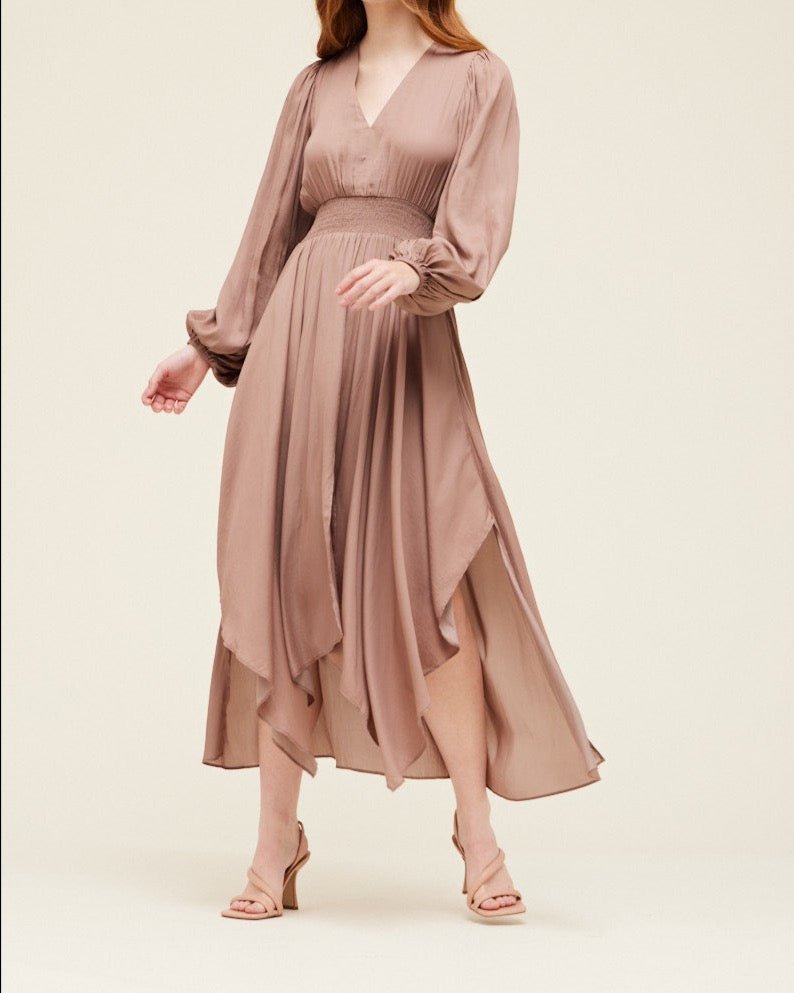 Elegant dusty orchid satin maxi dress with airy movement, long sleeves, and asymmetrical hem detail.