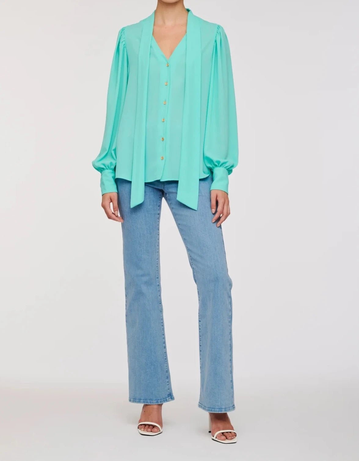 WEILL Paris turquoise long sleeve tie-neck blouse with loose neck ties and gold-tone buttons, worn with jeans