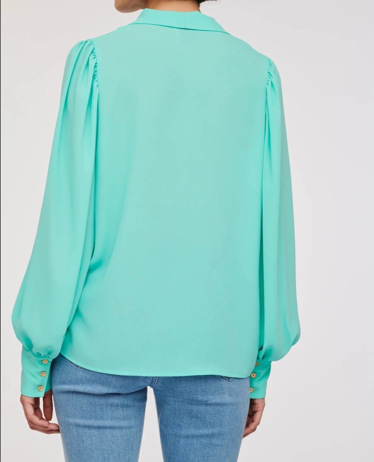 Back detail of WEILL turquoise blouse showing a flowing straight cut and gathered long sleeves