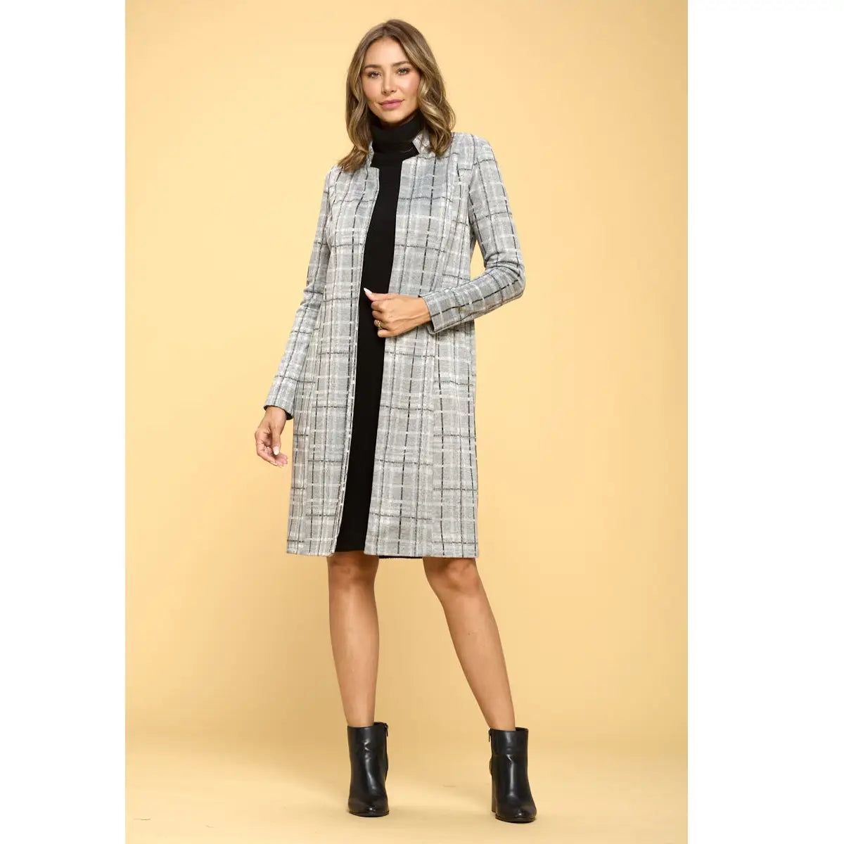 Full-length front view of Renee C grey plaid longline jacket layered over a black dress with ankle boots.