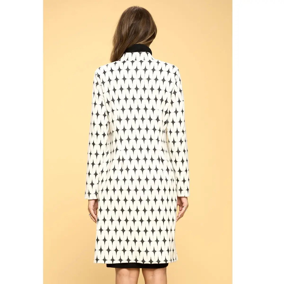 Back view of Renee C ivory and black geometric longline jacket showing the repeating oval pattern and straight hem.