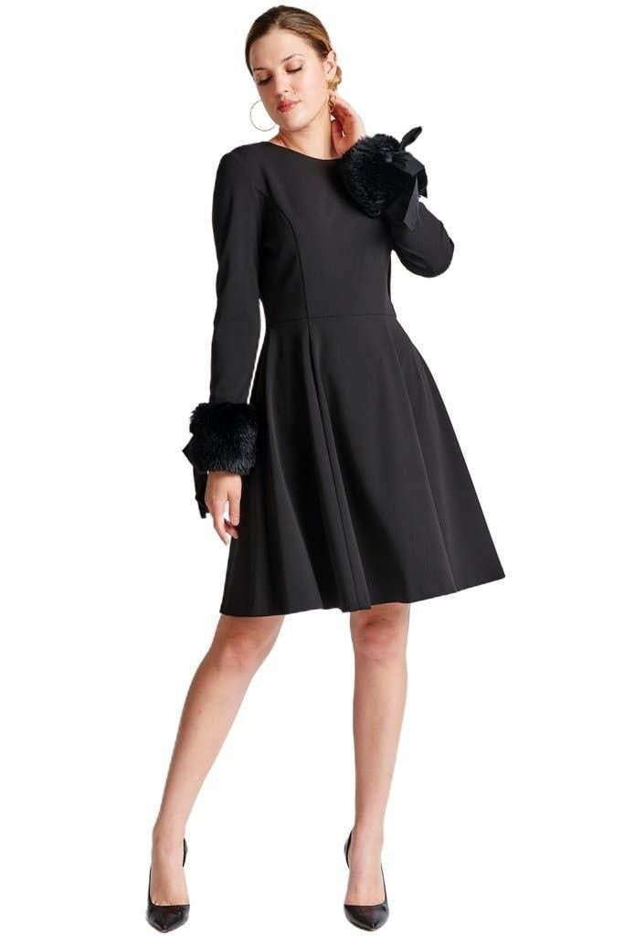Caroline black crepe dress with one arm raised, showing the faux-fur cuff, ribbon tie and flared skirt.