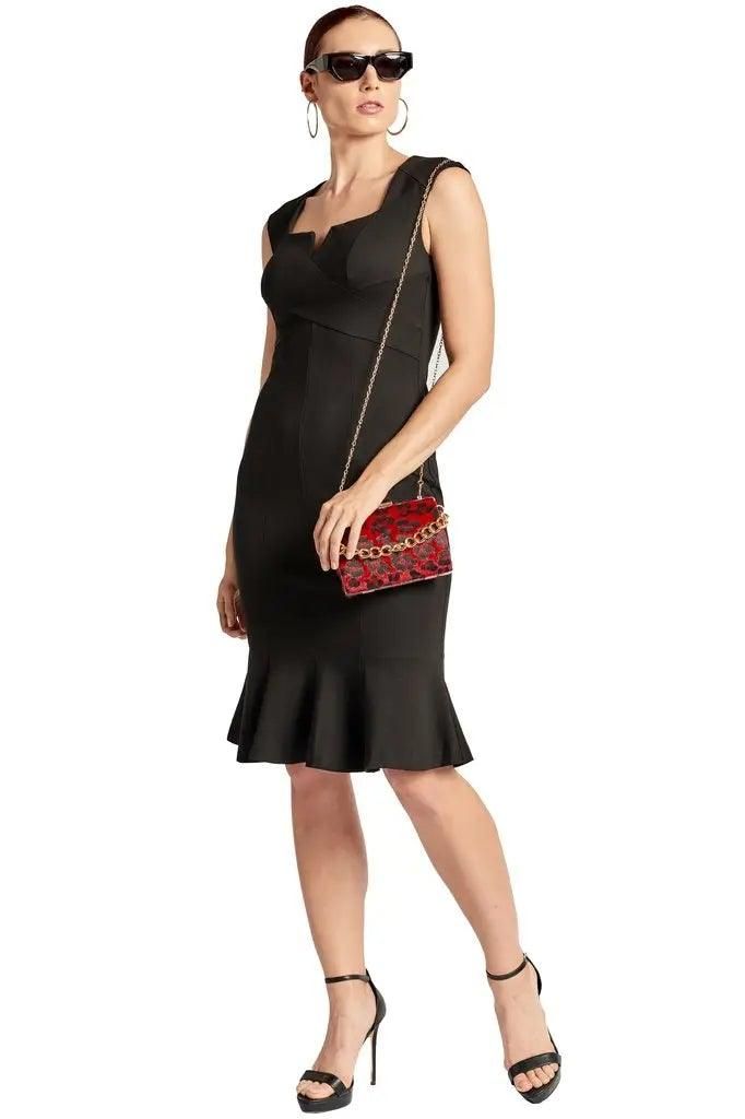 Simona Maghen Ivy black sleeveless ponte dress with a V-notched square neckline and mermaid hem, styled with a red crossbody bag.