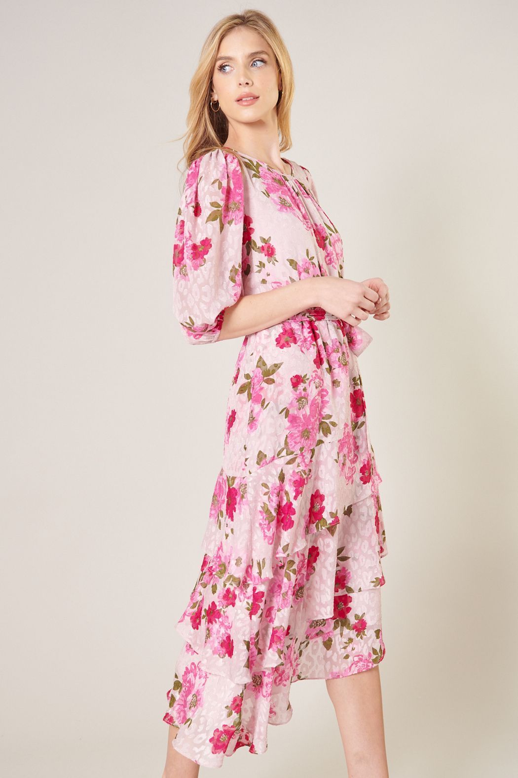 Side view of pink floral midi dress with tie waist and layered ruffle hem