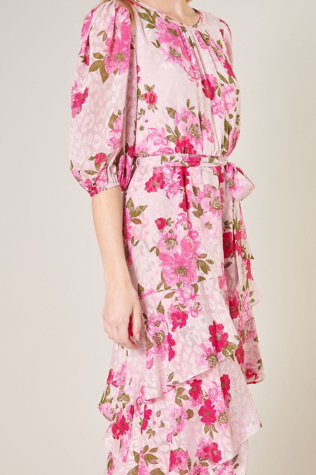 Close-up of gathered neckline, pink floral print, waist tie, and layered ruffle skirt