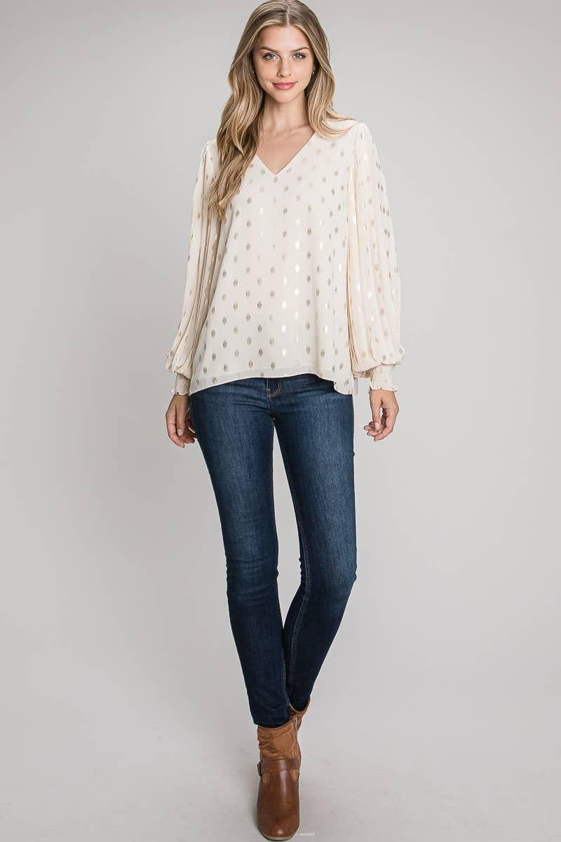 Full-length outfit with the champagne foil dot V-neck blouse worn untucked over dark jeans and brown ankle boots.