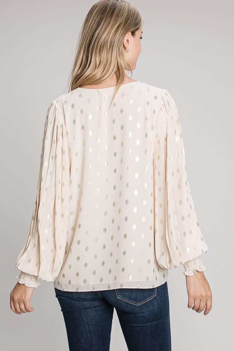 Back view of the champagne foil dot blouse showing its relaxed shape, long full sleeves and smocked cuffs.