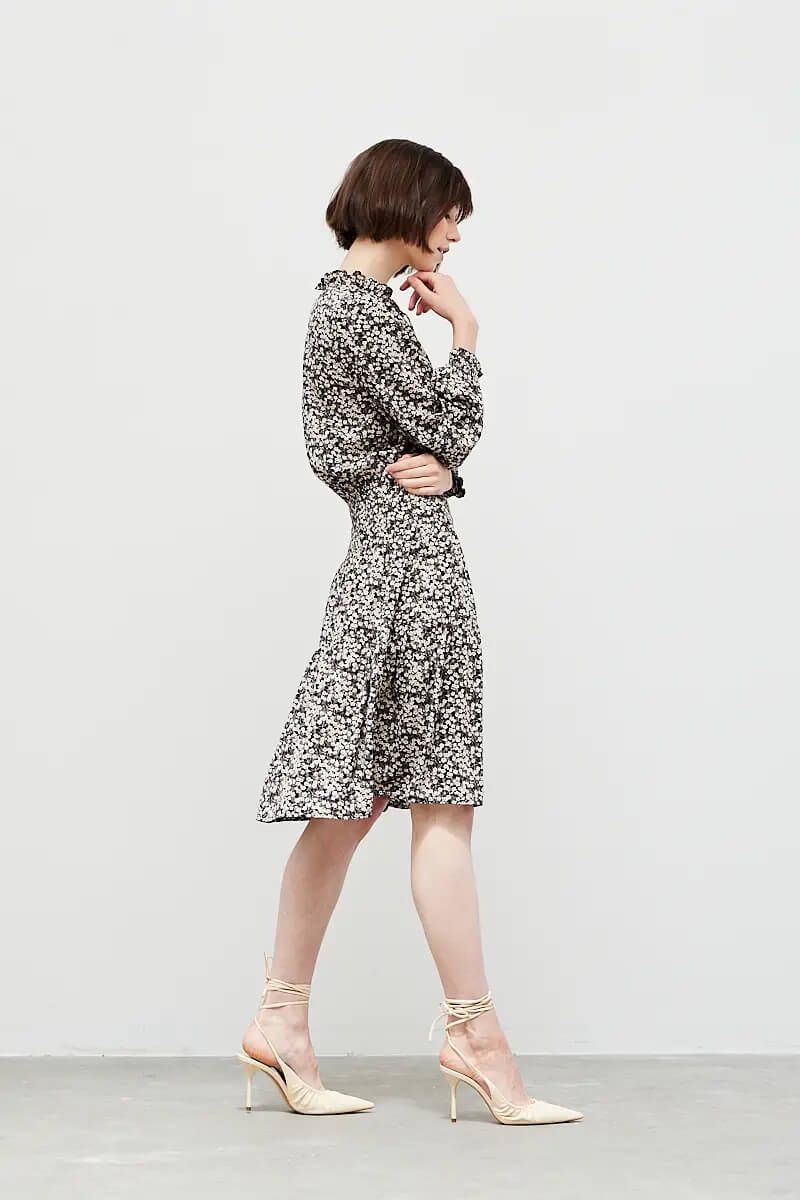 Side view of black ditsy floral knee-length day dress