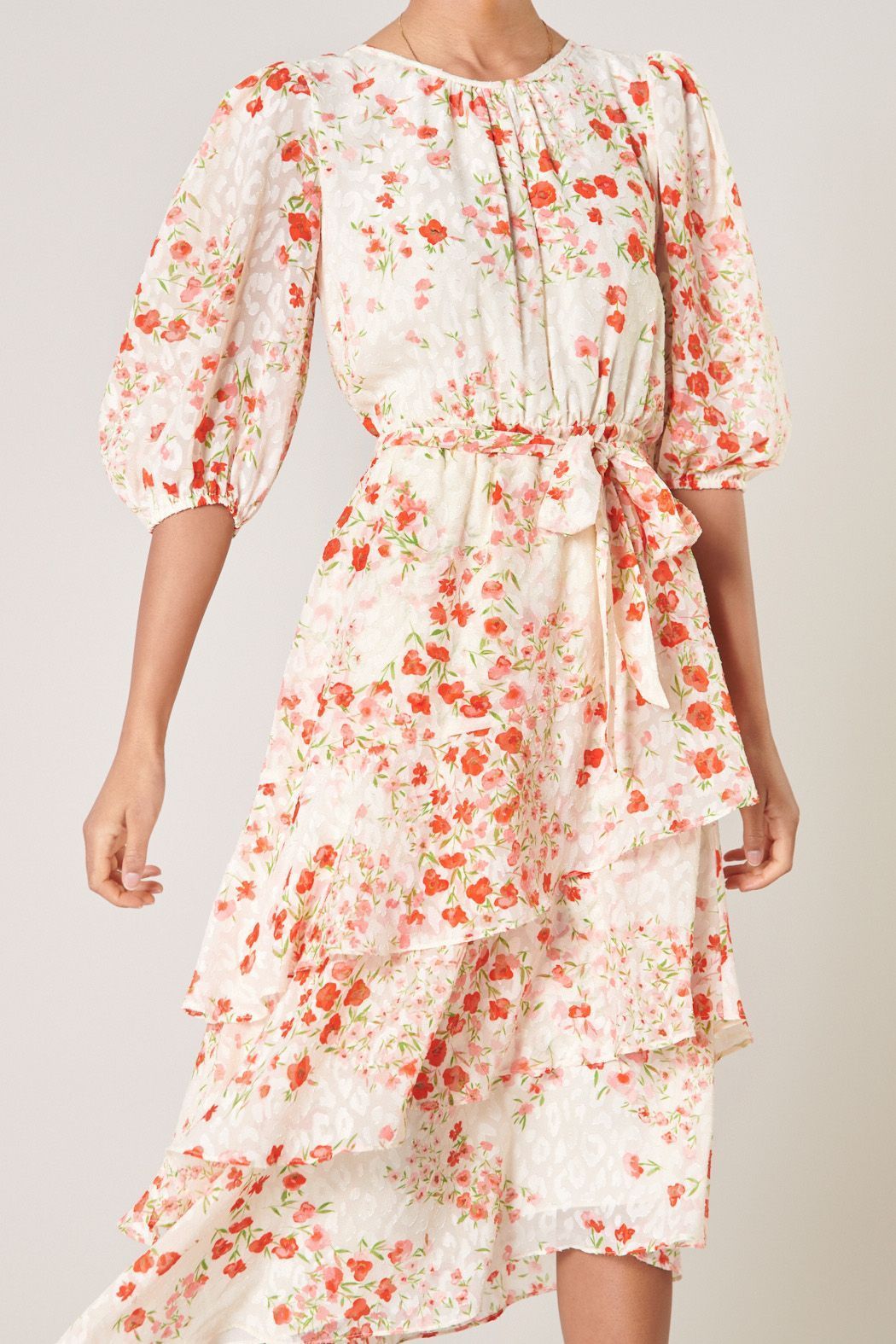 Close-up of blush floral print, gathered neckline, and puff sleeves on midi dress