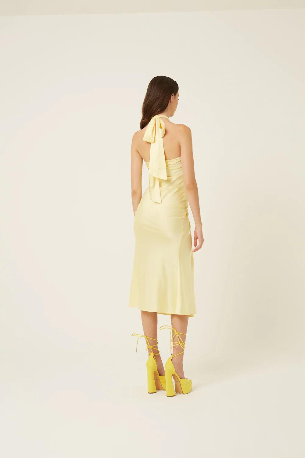 Back view of butter yellow satin midi dress with halter tie neckline