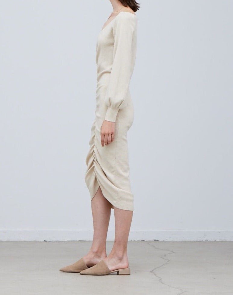 Side view of knit midi sweater dress showing gathered shirring detail and long sleeves