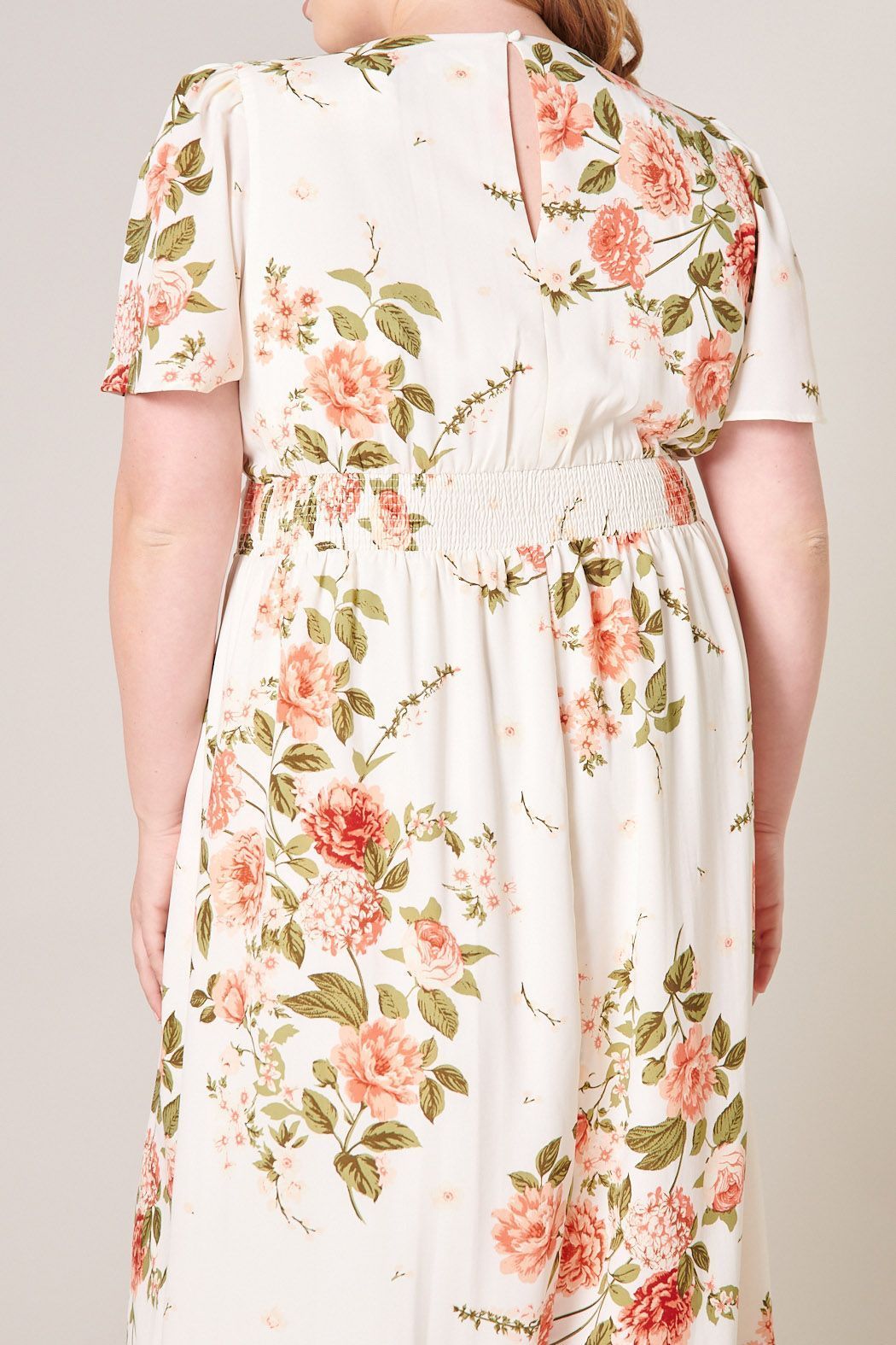 Close-up of vintage floral print and smocking detail on curve-friendly midi dress