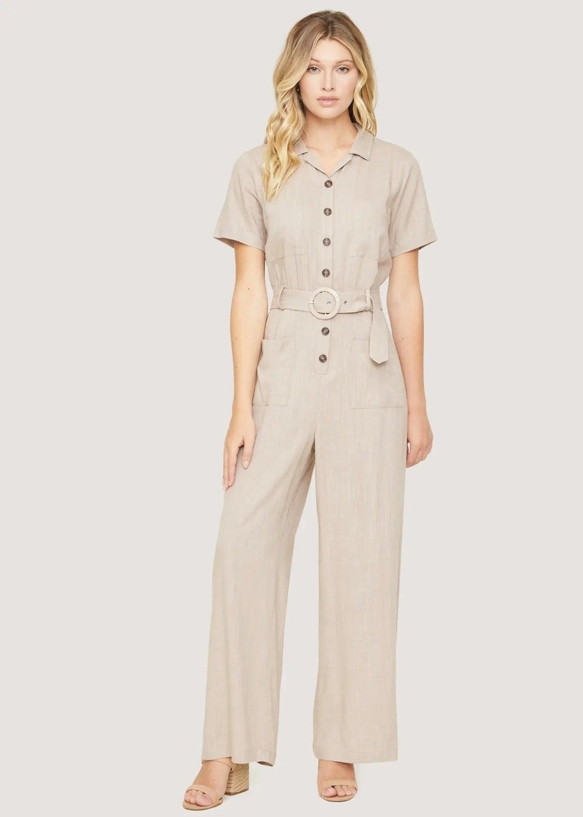 Front view of the Weekend Bliss almond linen blend jumpsuit with a matching round-buckle belt and patch pockets.